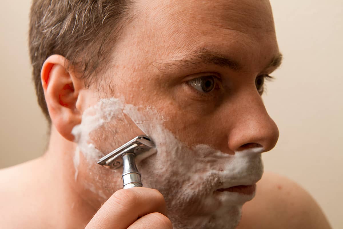 Mann rasiert sich mit Rasierhobel