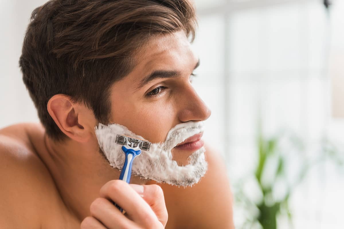 Mann rasiert sich mit Nassrasierer den Bart