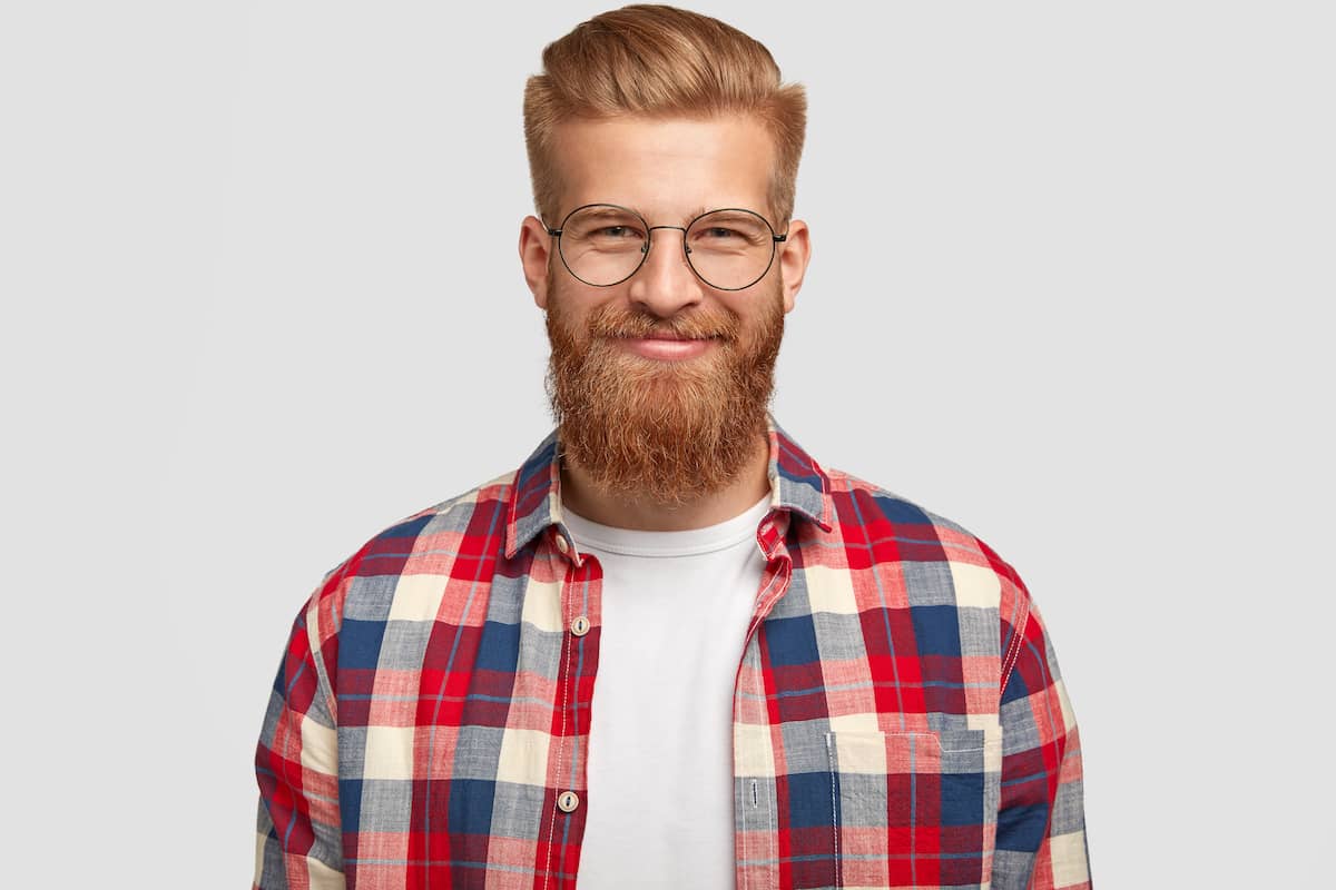 Mann mit Hipsterbart, runder Brille und Karohemd