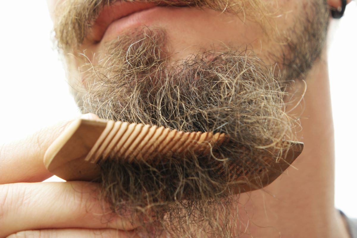 Mann kämmt seinen Bart