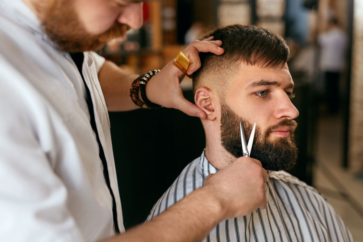 Barbier schneidet den Bart eines Kunden 
