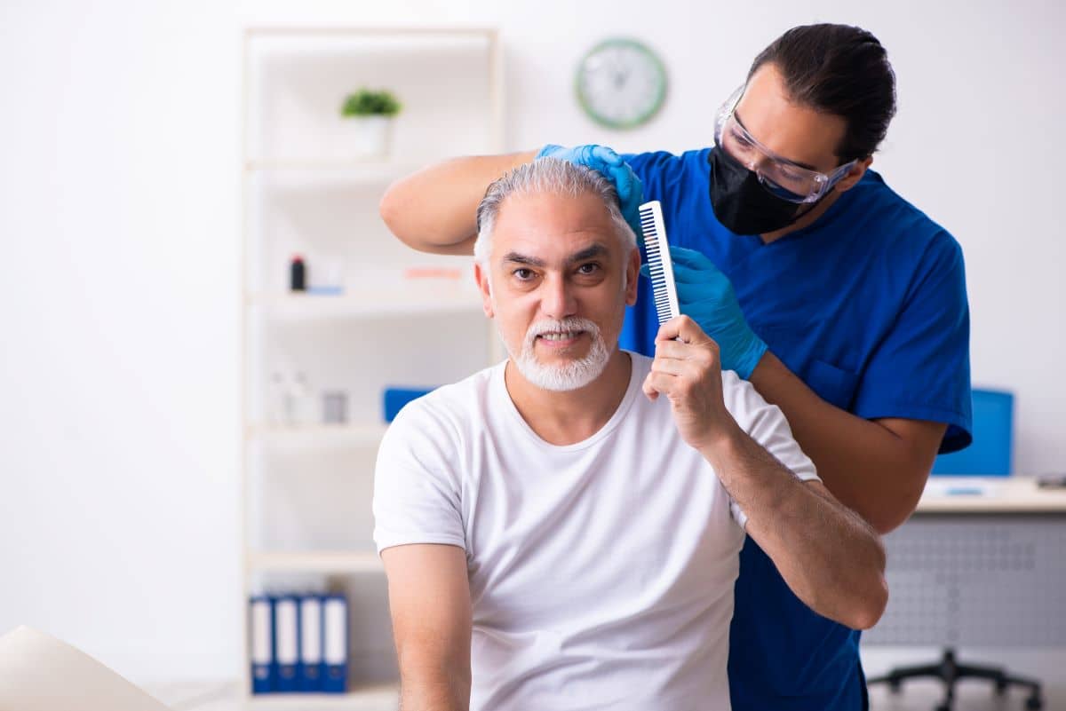 Mann beim Arzt, vor einer Haartransplantation